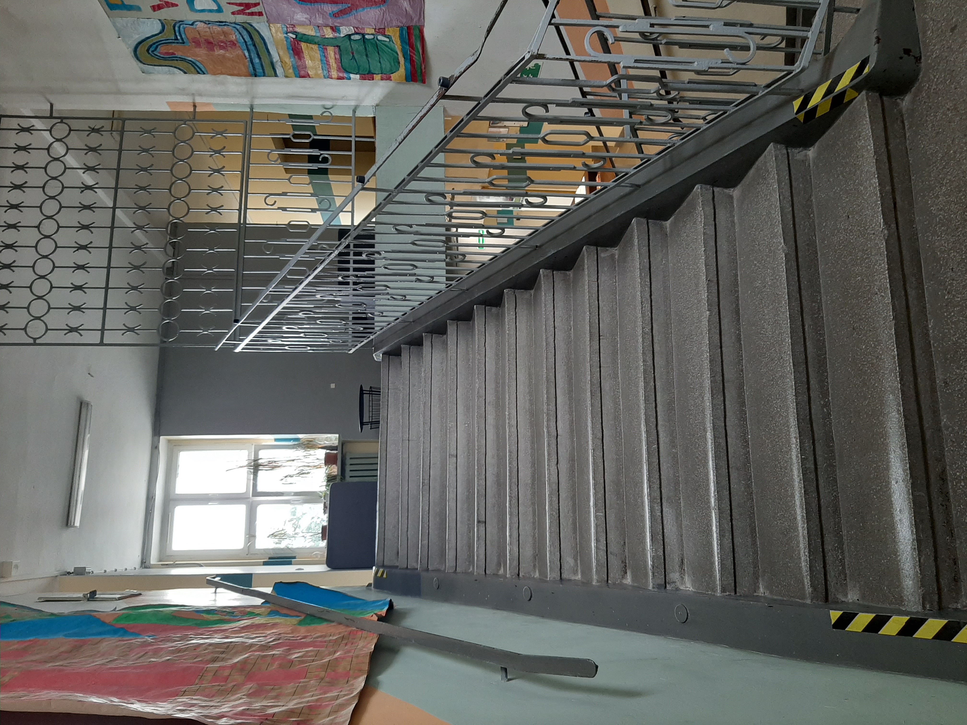 Zdjęcie prezentuje przykładową klatkę schodową prowadzącą na piętro szkoły.